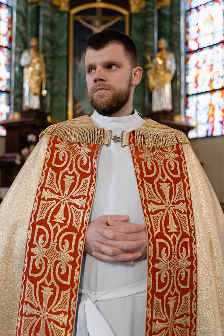 A Priest Wearing An Orange Colored  Stole