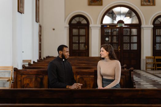 A Man and a Woman Sitting on Brown Wooden Pews