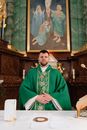 A Man in Green Chasuble Standing In Front of an Altar