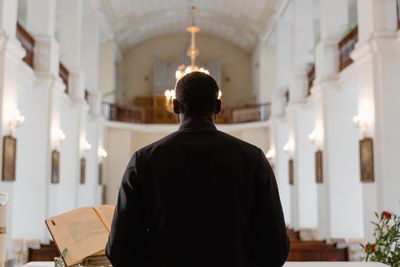 Pastor mid-sermon, Bible open in hand
