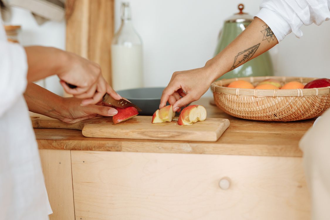 Mains coupant des fruits frais en cuisine : alimentation, base de la santé du microbiote et de la peau