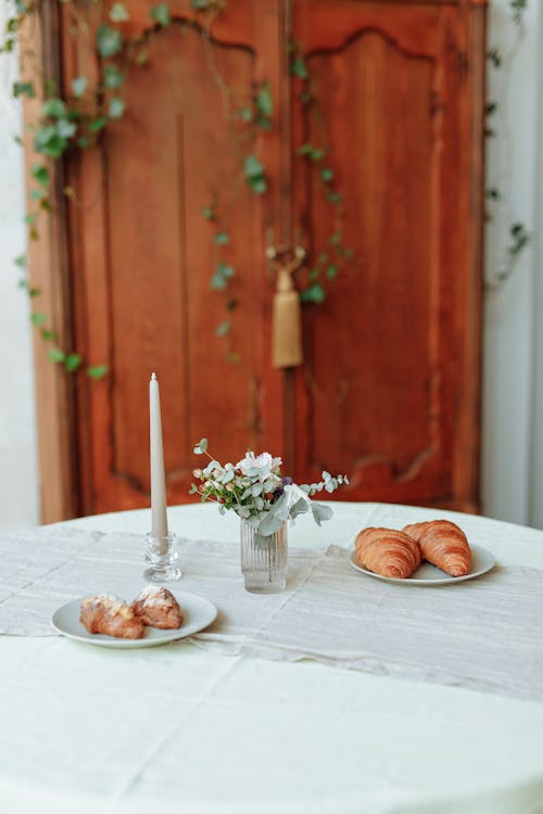 Free Two Plates of Croissants beside a Candle on a Table Stock Photo