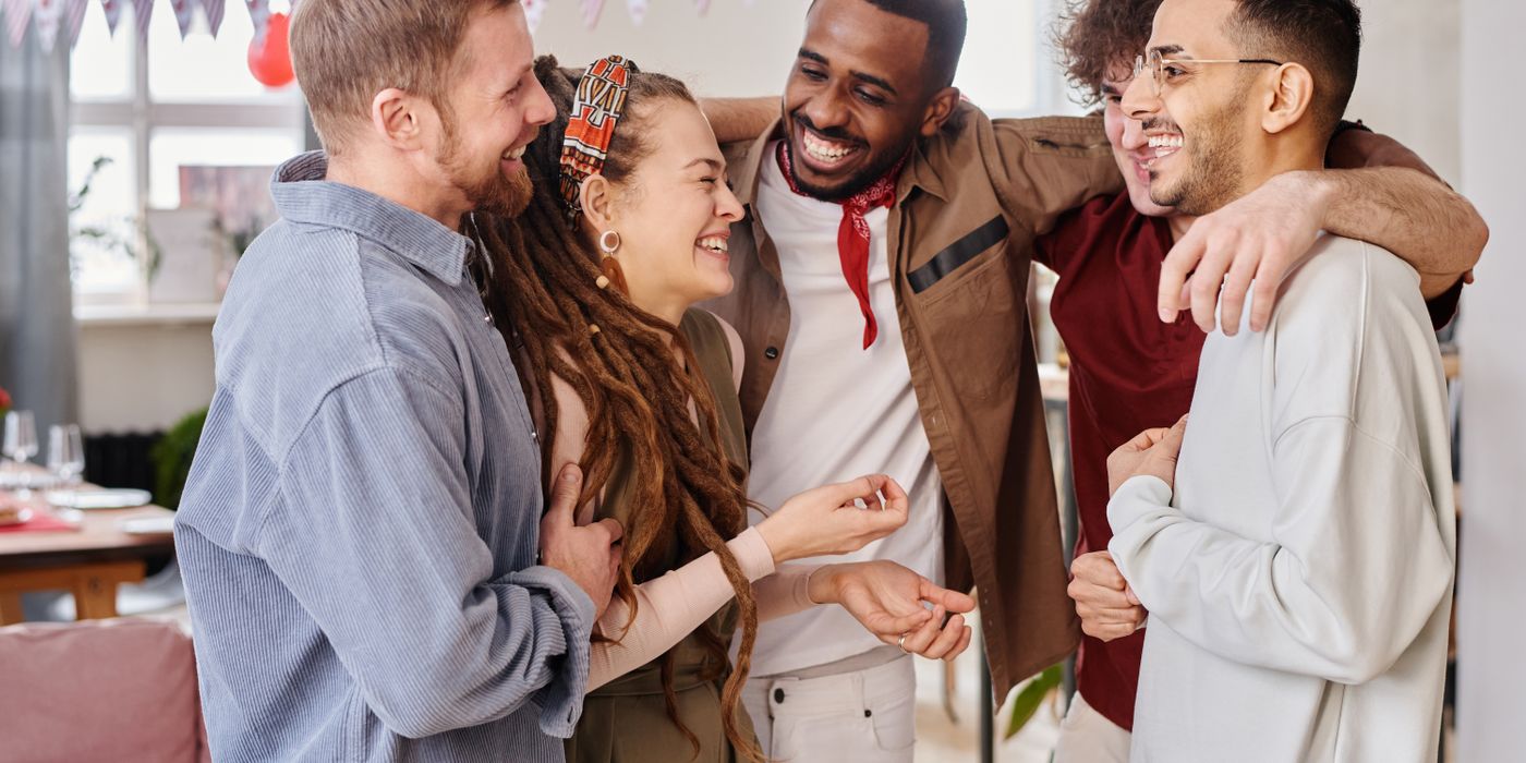 A joyful group of diverse friends celebrates indoors, embodying unity and happiness.