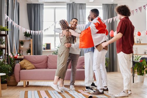 Free A joyful indoor celebration with diverse friends hugging and enjoying a festive atmosphere. Stock Photo