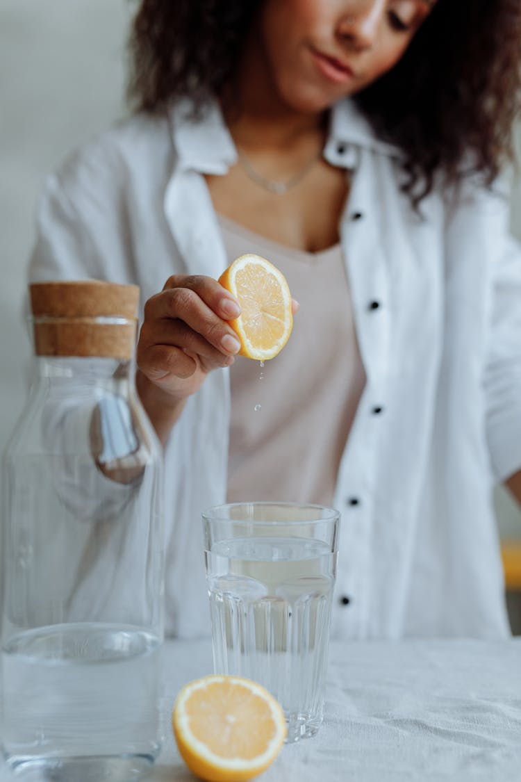 A Woman Squeezing A Lemon