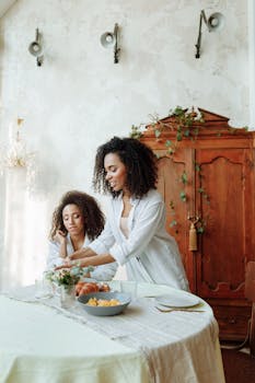 Two African American women having breakfast together in a cozy dining room setting.
