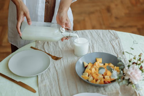 Free Close-Up Shot of a Person Pouring Milk on a Glass Stock Photo