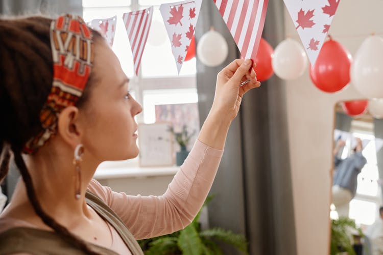 A Woman Hanging A Party Banner