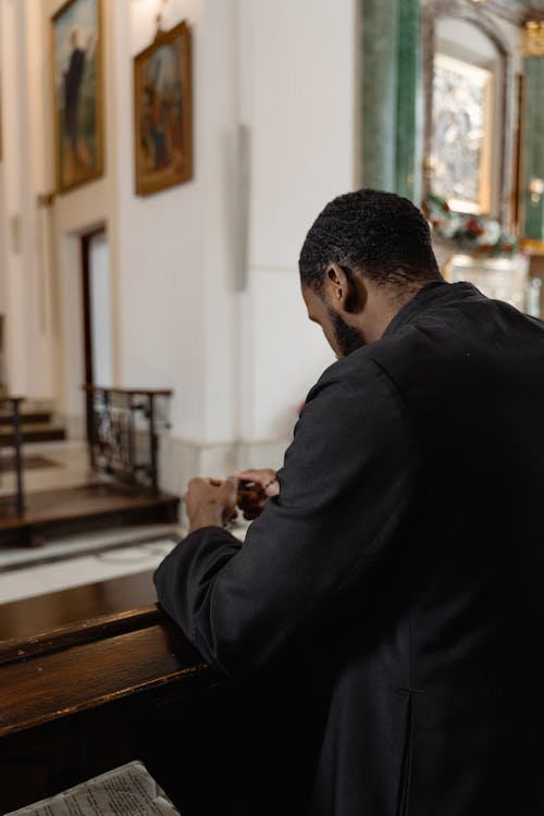 A Man in Black Long Sleeves Praying