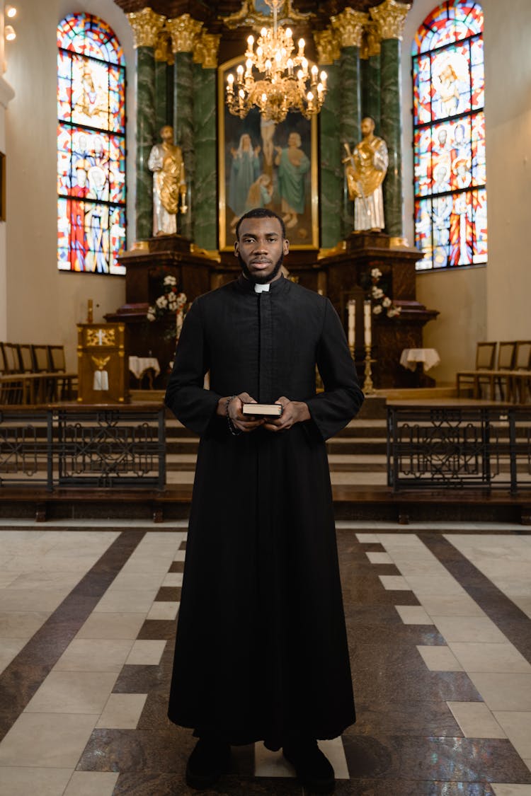 A Priest Holding A Bible