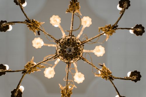Free Capture of a classic ornate chandelier with warm lighting viewed from below, enhancing interior decor. Stock Photo