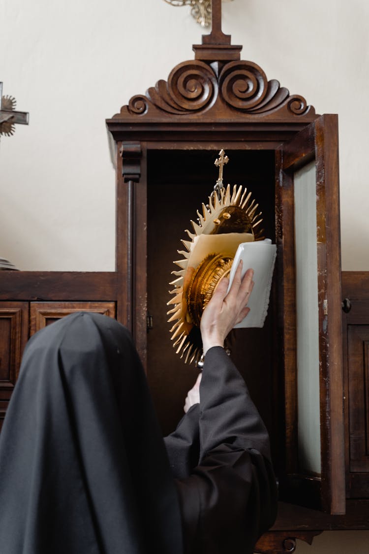 A Nun Wiping The Blessed Sacrament