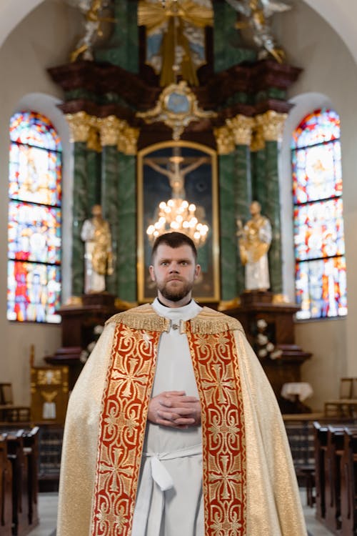 Priest in White and Red Chasuble Standing in Front of the Altar