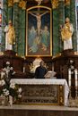 Priest in Black Robe Standing in Front of the Altar