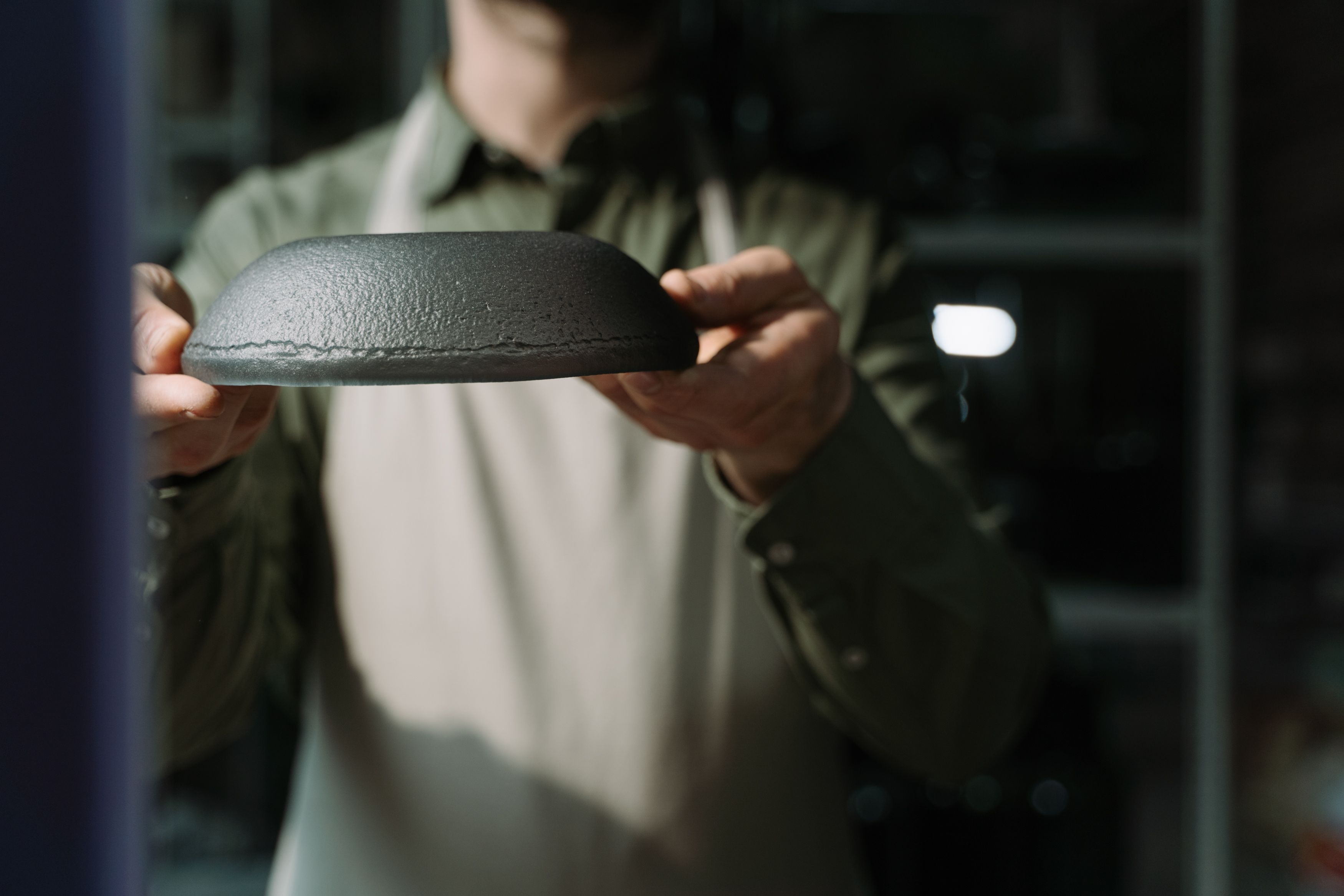 Close-up of an artisan holding a handmade ceramic bowl, showcasing craftsmanship.