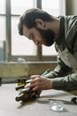 A Bearded Man Cutting a Wine Bottle