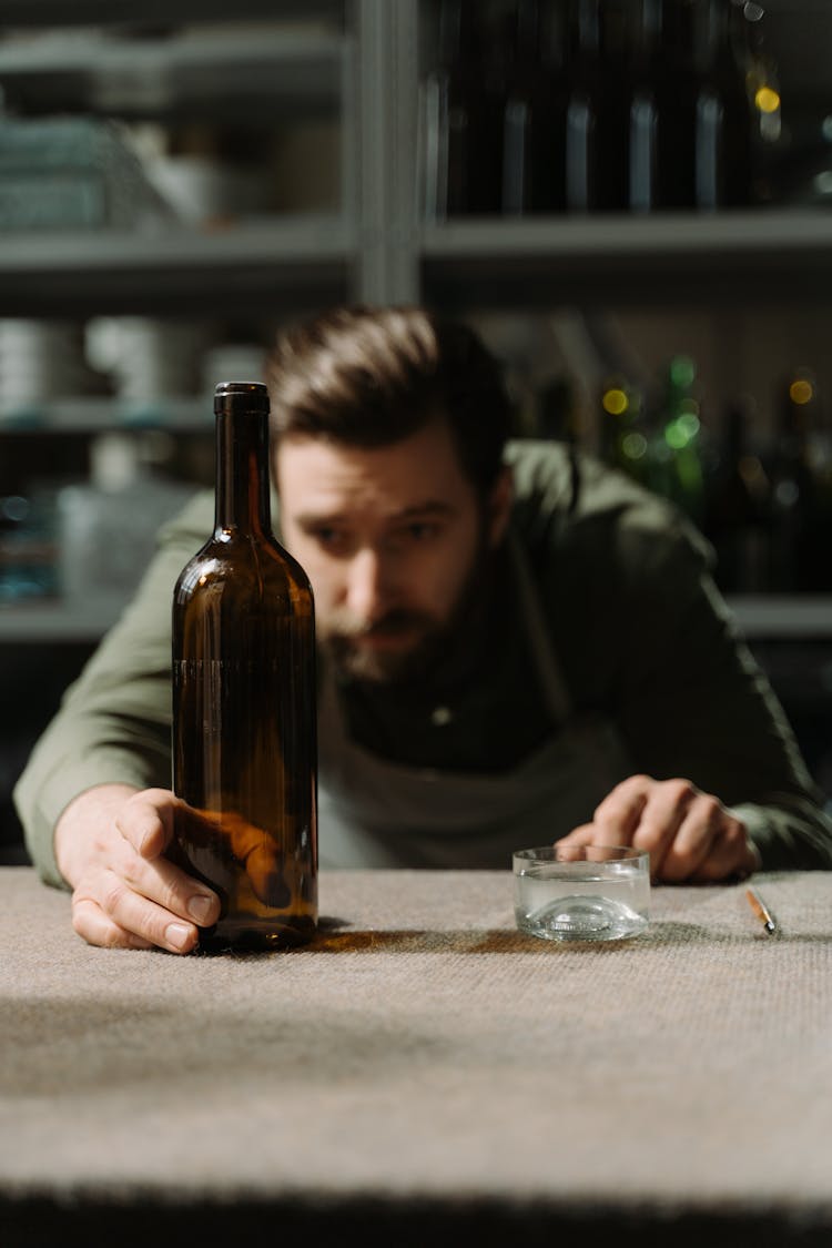 A Man Holding A Glass Bottle