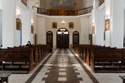 Free A serene view inside an empty church featuring classic wooden pews and religious decor. Stock Photo