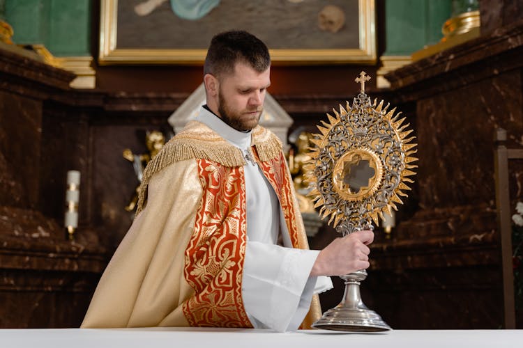 A Priest Holding A Monstrance