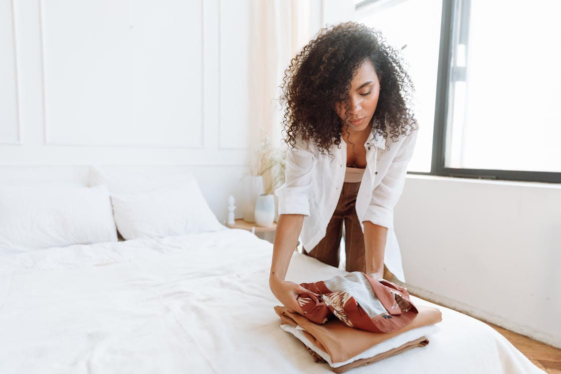 Free Woman in White Shirt Sitting on Bed Stock Photo