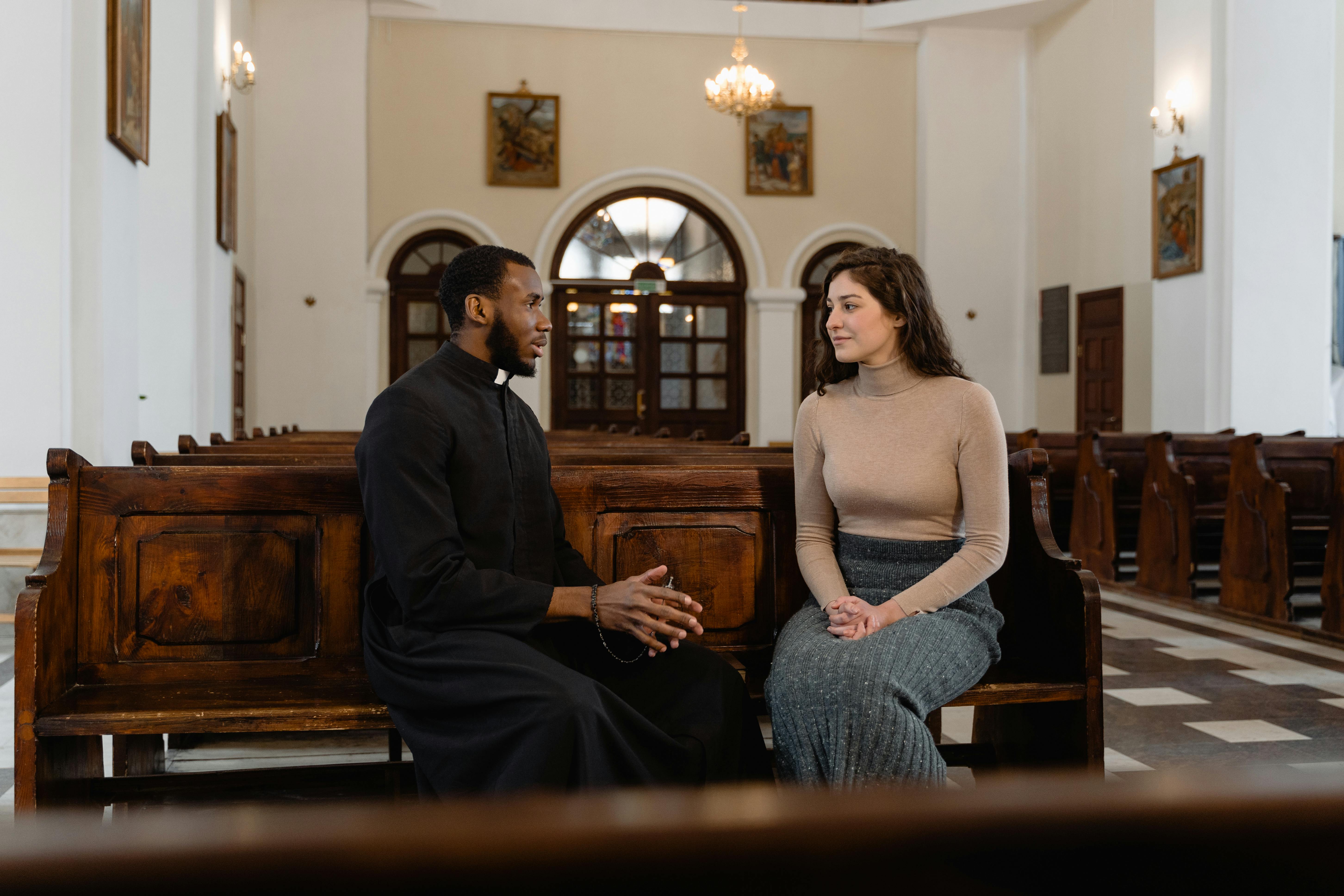 man and woman sitting on brown wooden bench