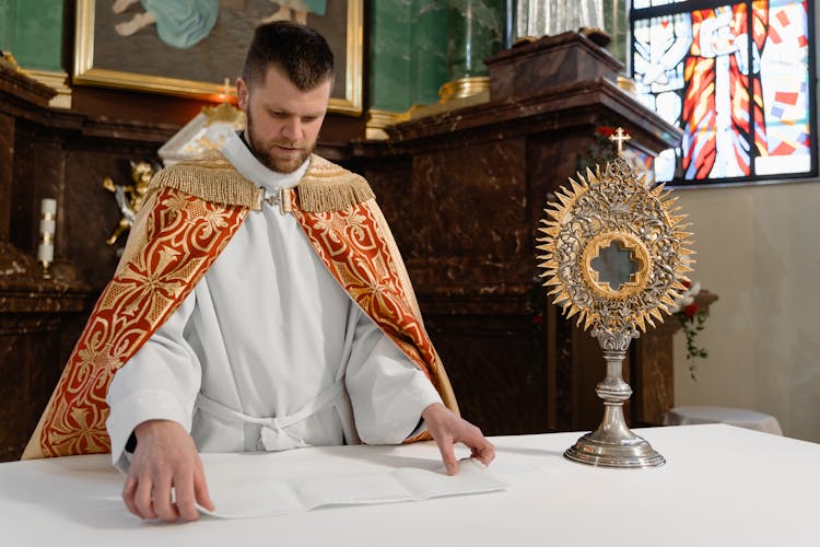 A Priest Holding A Monstrance