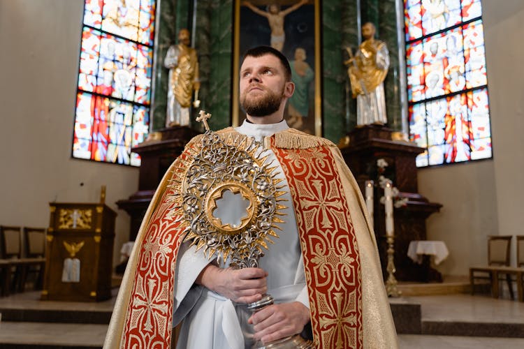 A Priest Holding A Monstrance