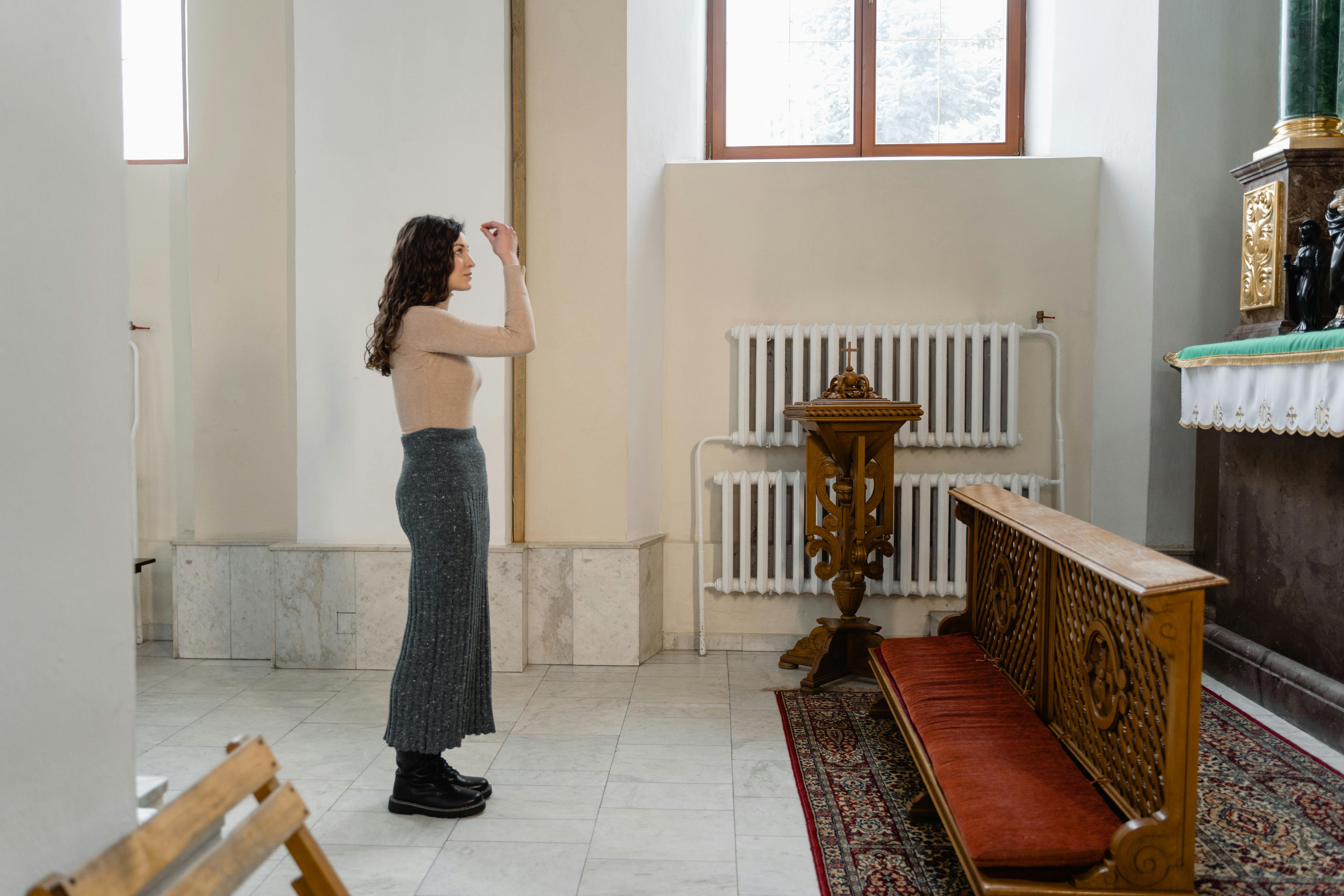 woman in gray tank top and gray leggings standing on red and brown area rug