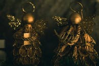 在温暖的灯光下，两个闪闪发光的金色天使装饰品被捕捉，象征着节日装饰