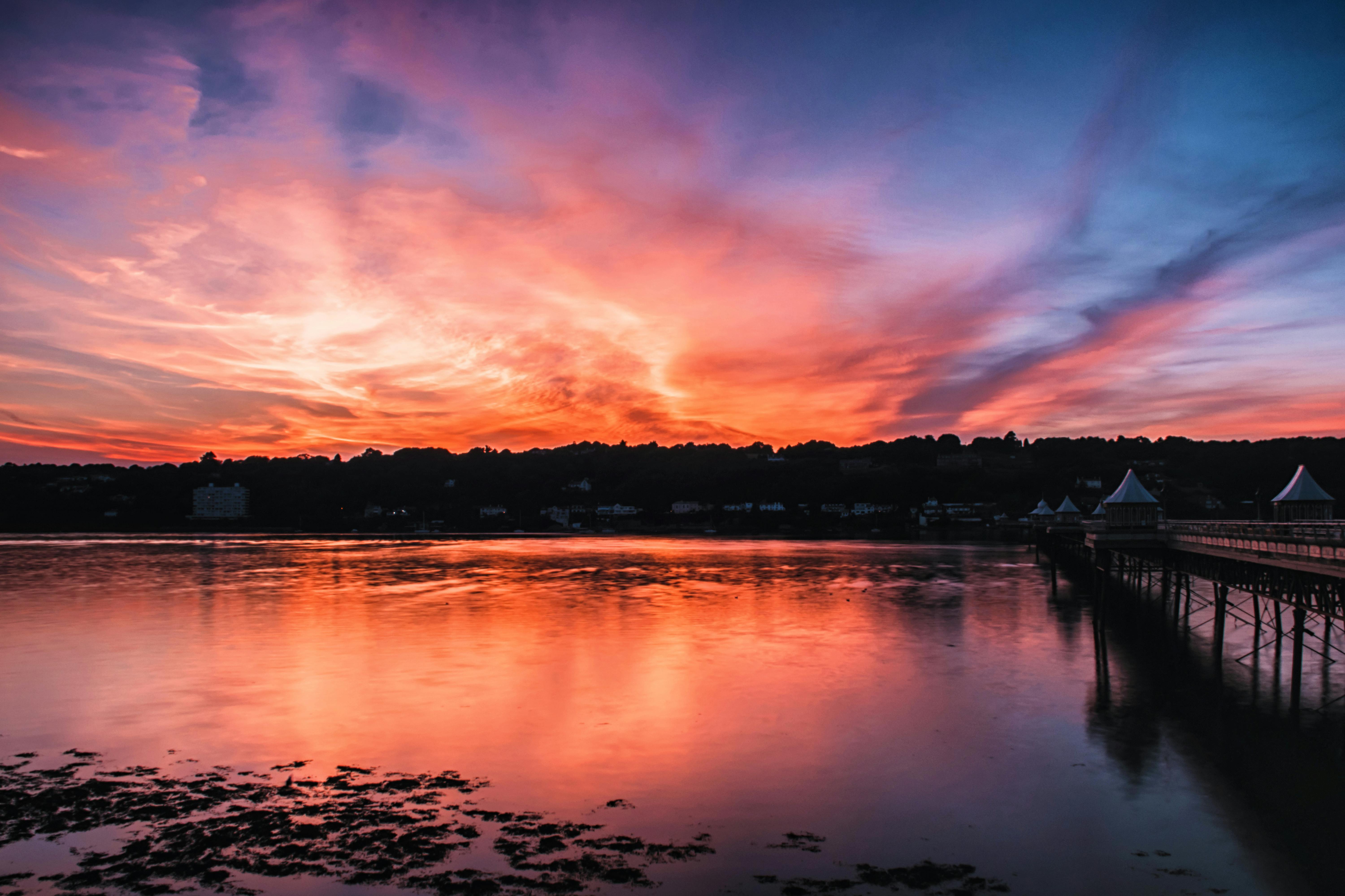 一座风景秀丽的桥梁旁，平静的河水倒映着令人惊叹的日落天空