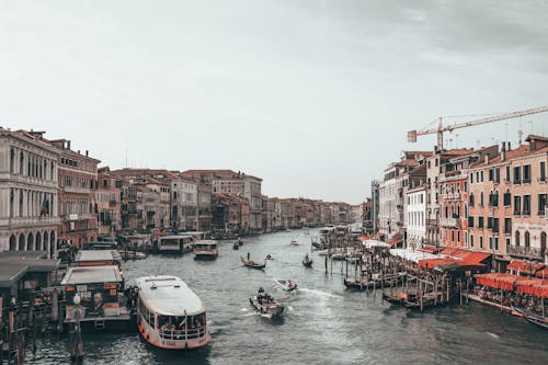 Free Gondolas and ferries on canal between buildings in city port Stock Photo