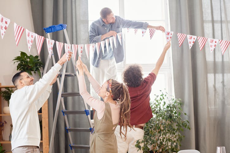 
People Hanging Decorations For A Party