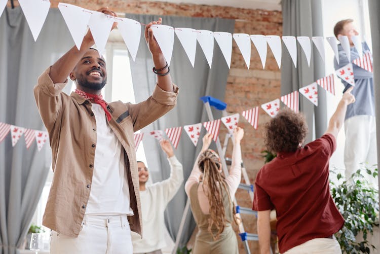 
People Hanging Decorations For A Party