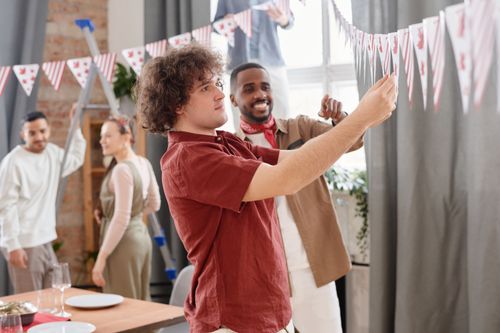 Free Group of friends preparing decorations for a festive party indoors. Stock Photo