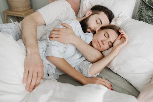 A Man Hugging a Woman while Sleeping