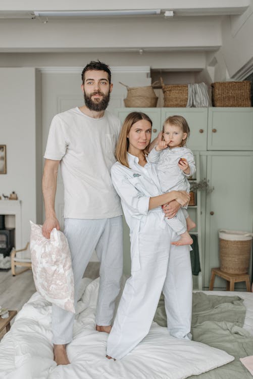 Happy Family Standing on Bed