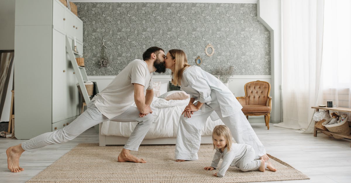 A family enjoying playful bonding moments in a stylish, minimalistic bedroom setting.