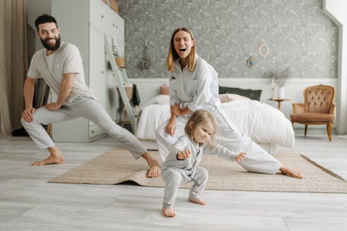 Free A Couple Stretching Their Legs while Looking at Their Cute Daughter Stock Photo