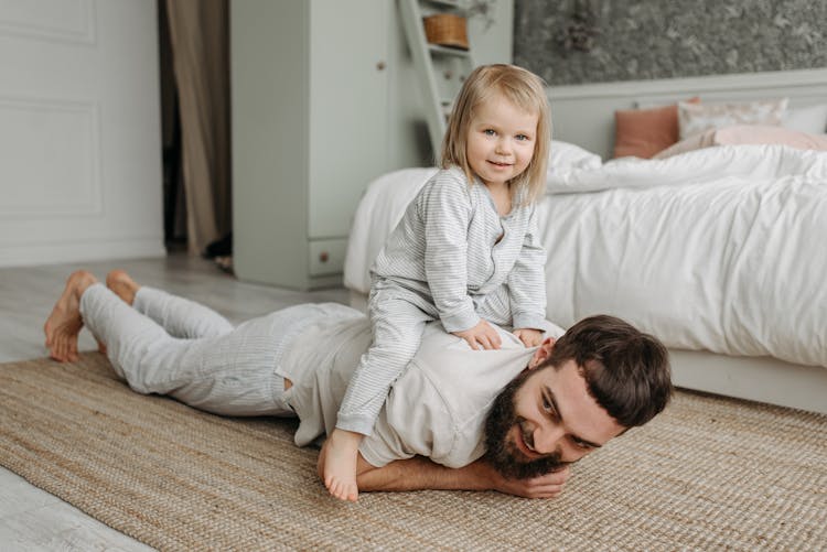 A Kid Sitting On His Father's Back