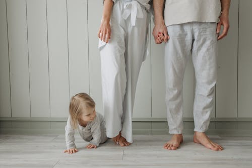 Free Girl Crawling Between Parents Legs Stock Photo