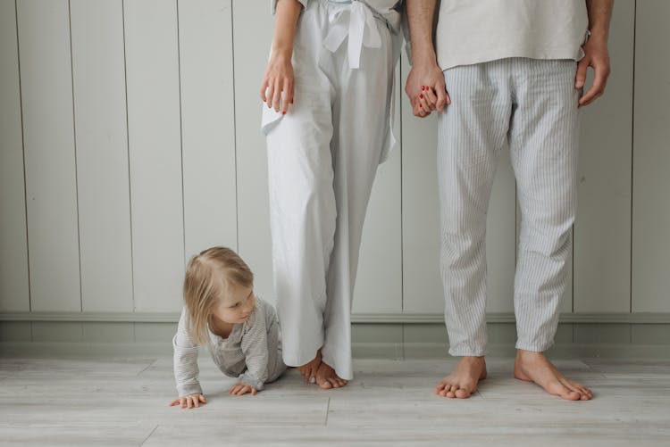 Girl Crawling Between Parents Legs