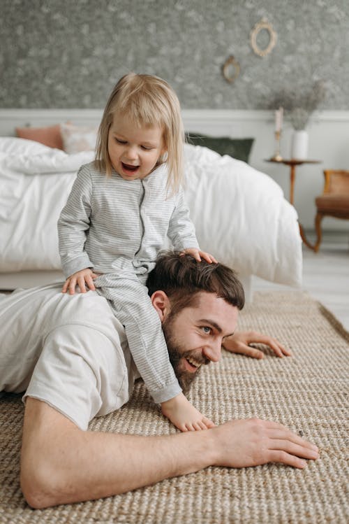 Free A Cute Baby Sitting on Her Father's Back Stock Photo