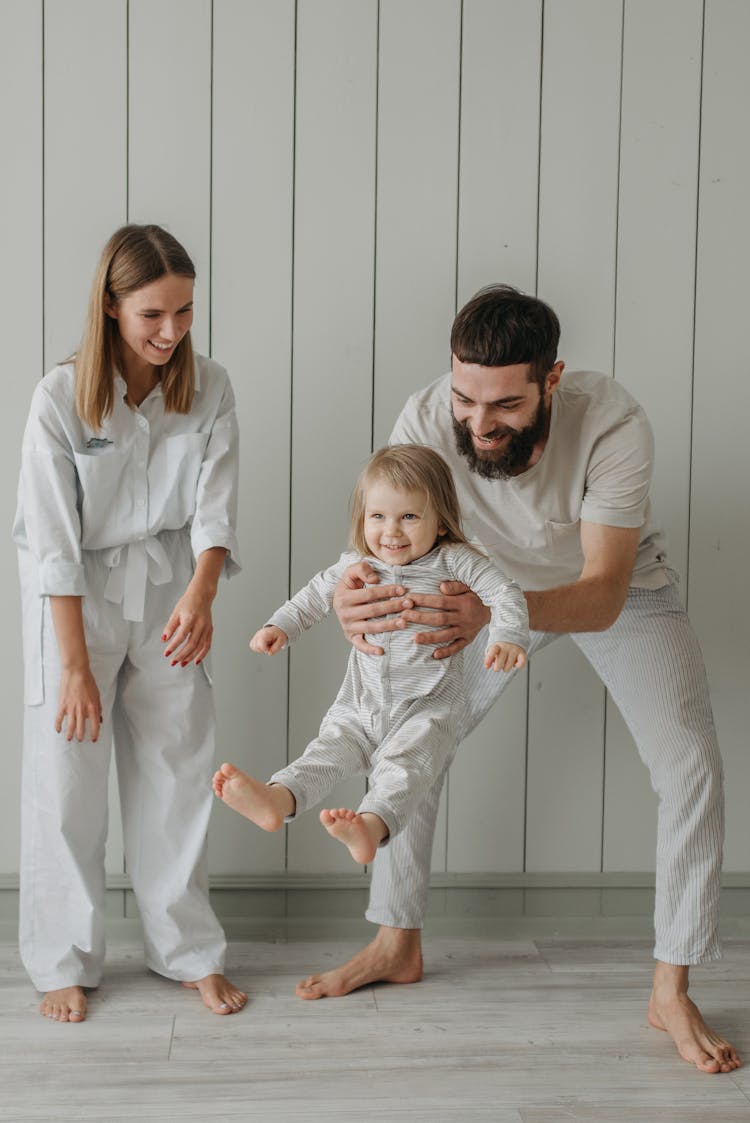 A Father Carrying His Child Near A Woman