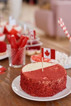 A delicious red and white cake with a Canadian flag for a festive celebration.