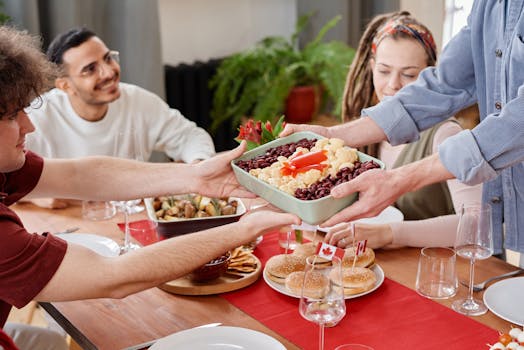 Joyful group of friends enjoying a meal together on Canada Day indoors.