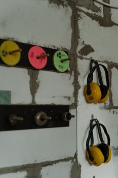 Ear protectors and sanding pads displayed on a workshop wall.