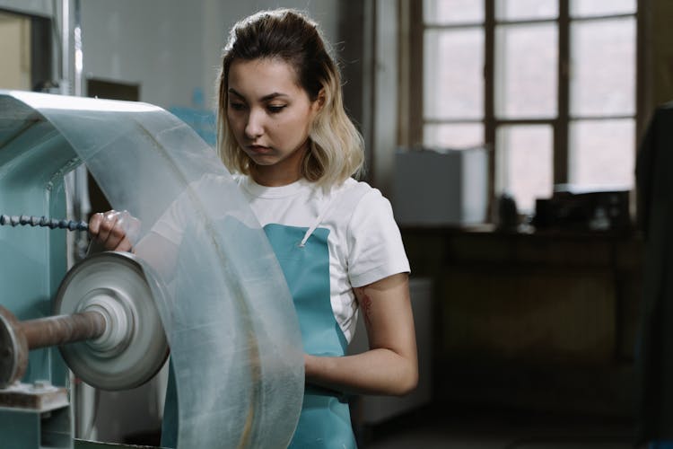 A Woman Using A Machine Inside A Shop