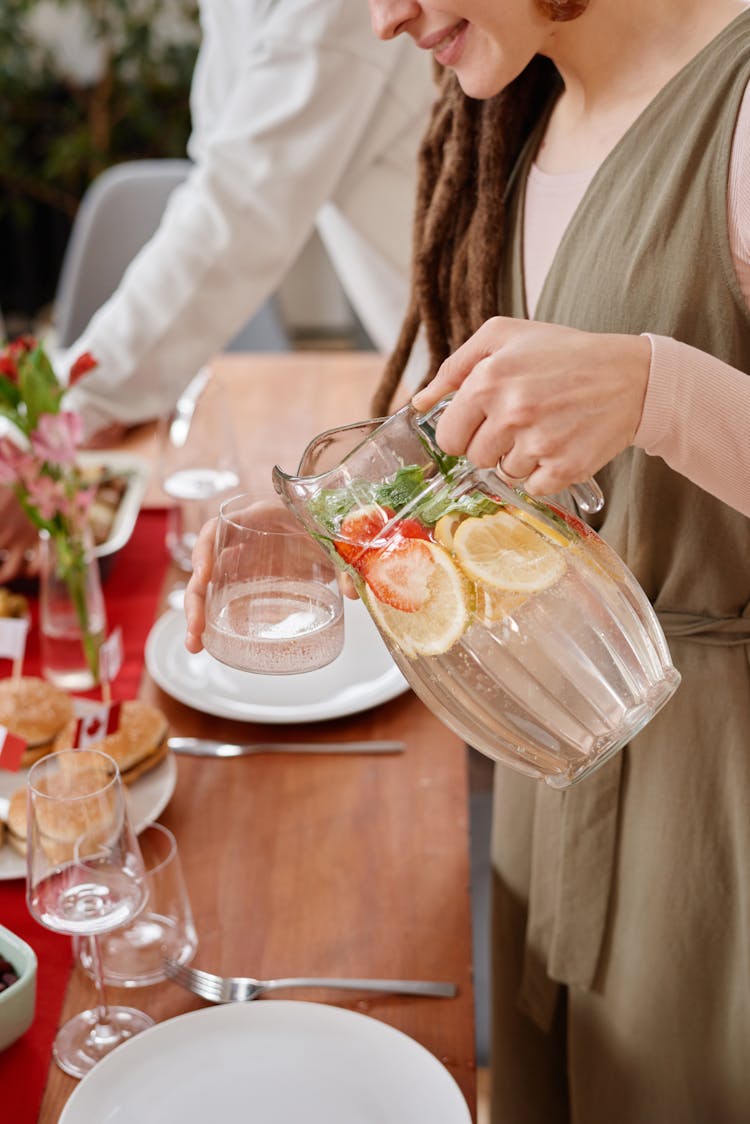 A Woman Pouring Drink In A Glass