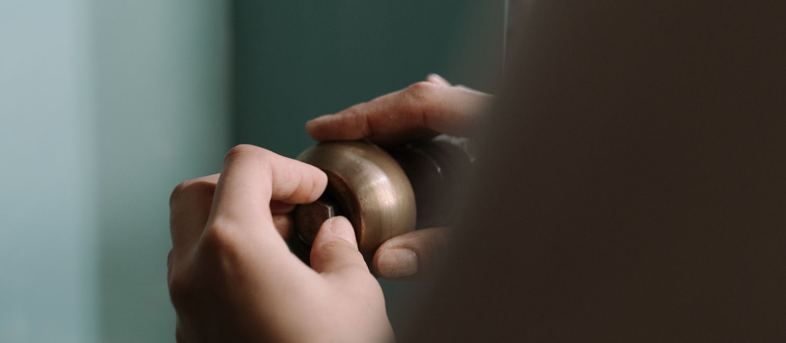 Hands fitting a pipe under a kitchen sink