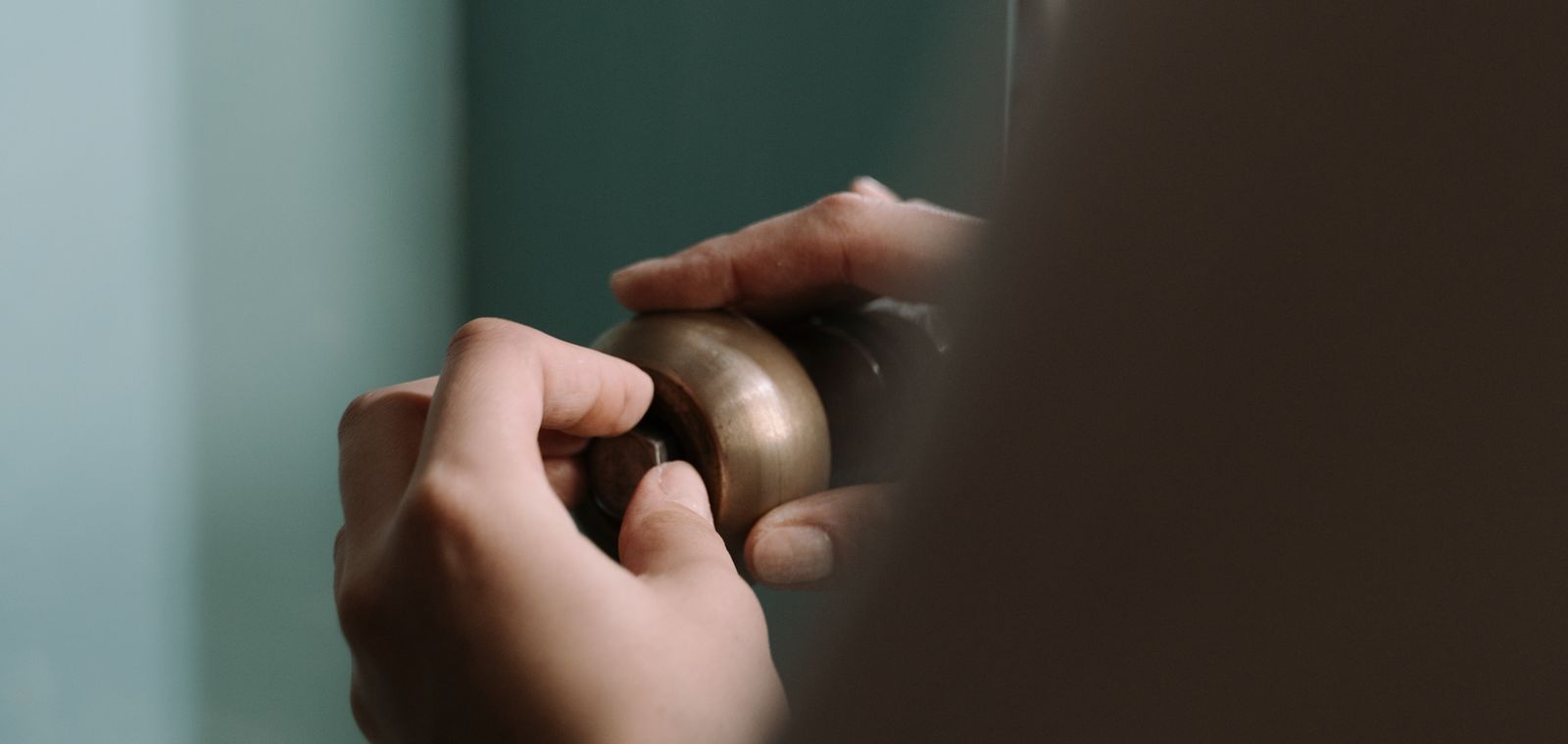 Hands fitting a pipe under a kitchen sink
